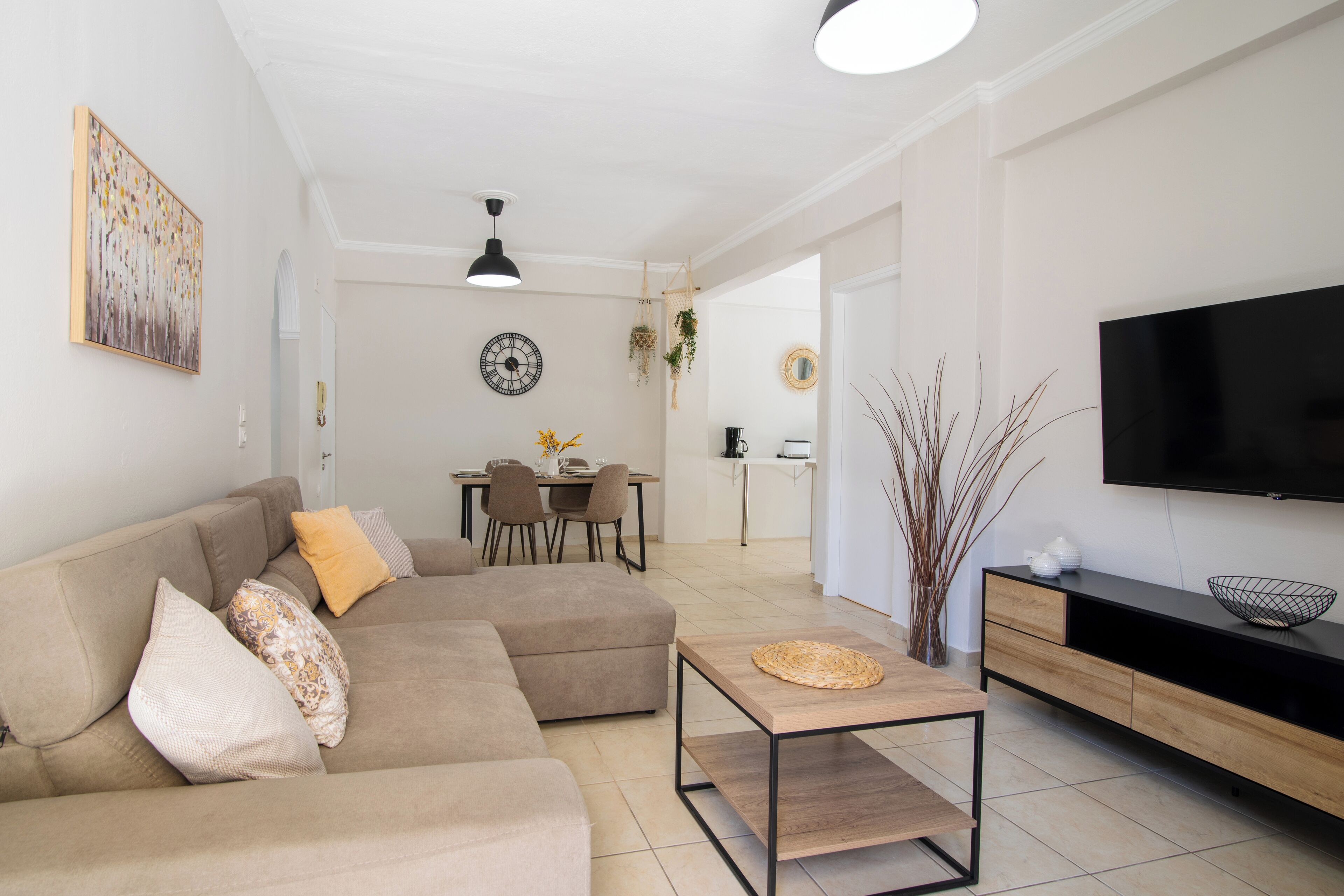 A modern living room with a sectional sofa, a coffee table, and a flat-screen TV.