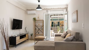 En moderne stue med sofa, fjernsyn og et træskab.