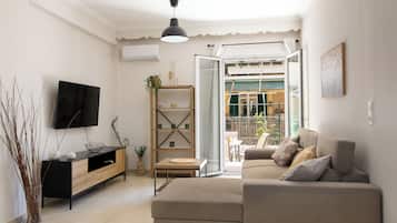 Una sala de estar moderna con un sofá, televisor y un mueble de madera.