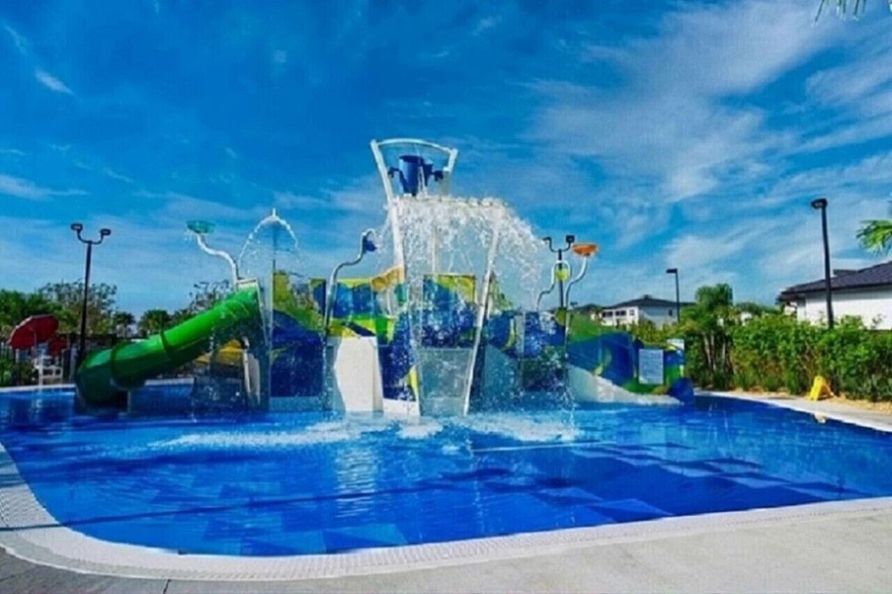 Une piscine avec un toboggan aquatique et un toboggan en forme de tube vert.