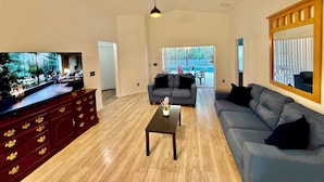 Ein Wohnzimmer mit Fernseher, Sofa und Holzschrank.