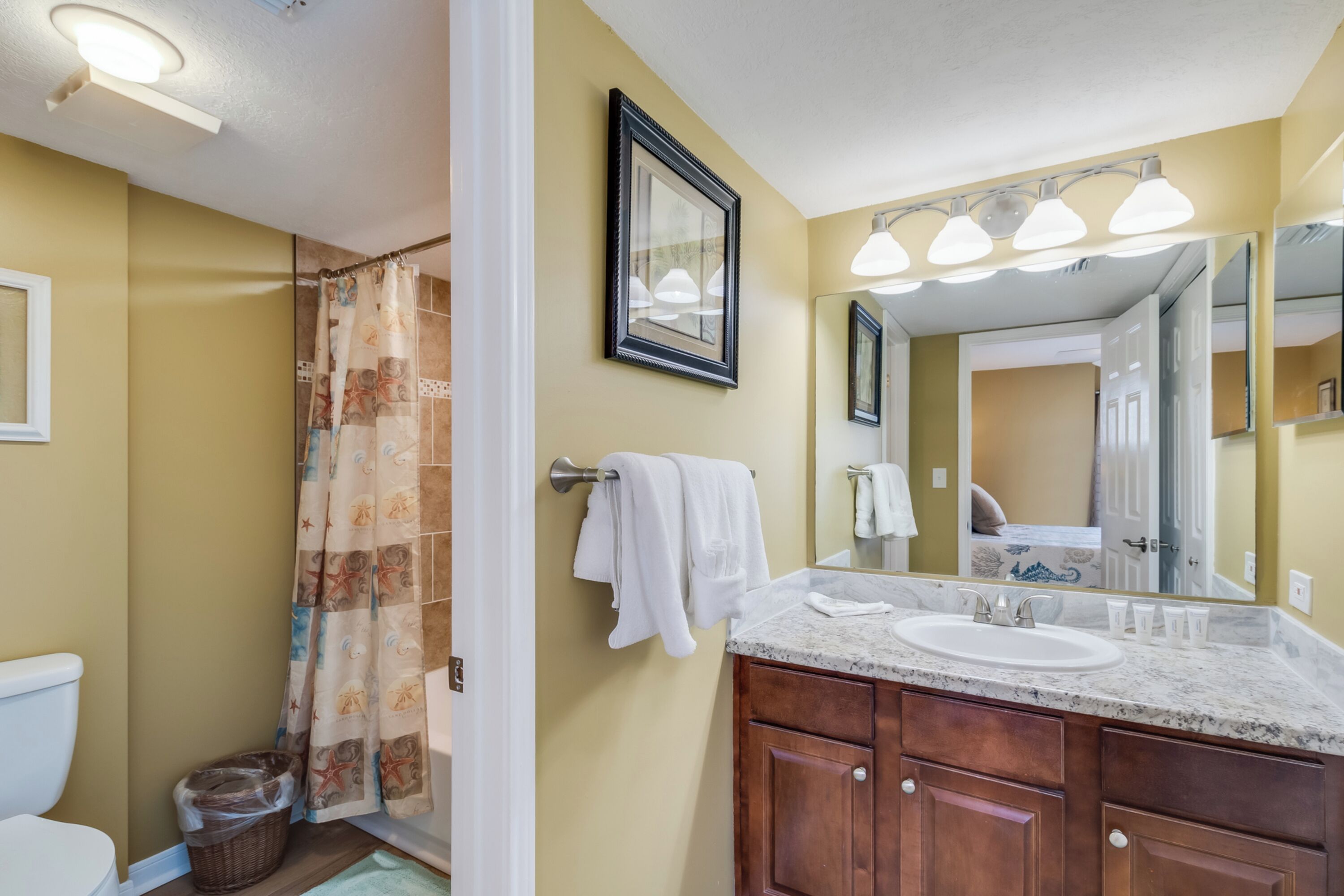 Une salle de bain avec une douche, un lavabo et un miroir.