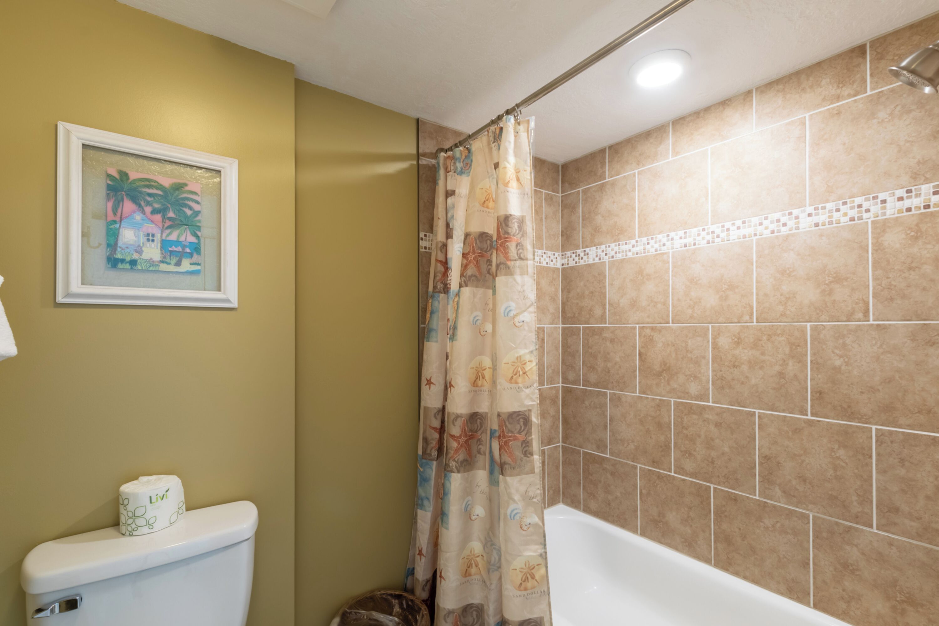Une salle de bain avec des toilettes, un rideau de douche et une baignoire.