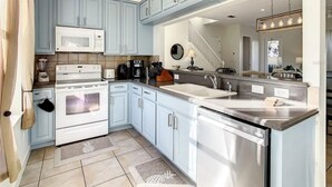 A modern kitchen with light blue cabinets, a stainless steel dishwasher, a built-in oven, and a microwave. - Reunion Resort 3 bed With Private Pool (Kissimmee)