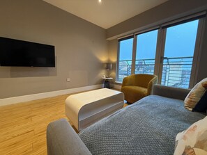 Leilighet – deluxe, balkong, byutsikt | Oppholdsområde | En 50-tommers smart-TV med digitale kanaler samt Netflix