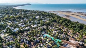 Une station balnéaire dotée de plusieurs hébergements de type bungalow, d’une plage et offrant une vue dégagée sur l’océan.