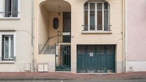 Edifici de dues plantes amb un ull de bou, un balcó i l'entrada al garatge.