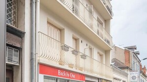 A multi-story building with a ground-floor shop named "Bach In One" and a visible storefront with a sign reading "TATOUAGENS".