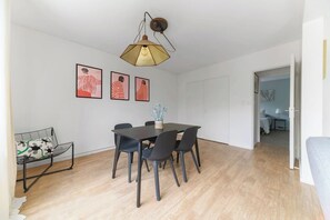 Un espace repas comprenant une table, des chaises et un luminaire suspendu.