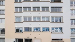 A multi-story residential building with a flat facade, multiple balconies, and a ground-level entrance. - Le Raymond - 48 allée des ailes - Vichy (Vichy)