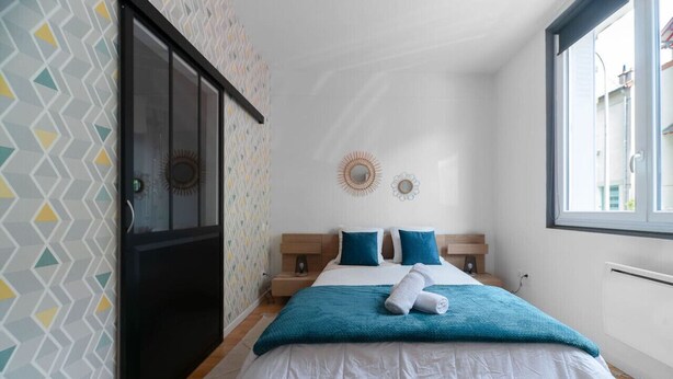 Una camera da letto con un letto, due cuscini, una finestra e una porta.