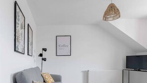 Una sala de estar moderna con un sofá gris, una mesa de centro blanca y una alfombra estampada.