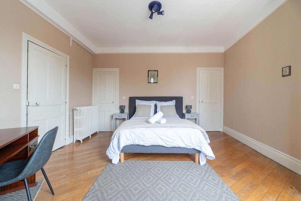 Una camera da letto con un letto, comodini, una scrivania e una sedia.