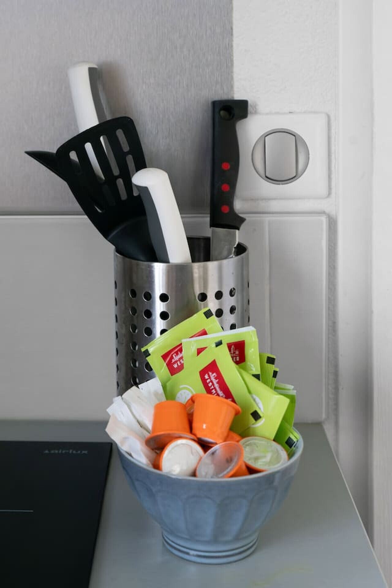 Suporte de utensílios de cozinha com espátula, faca e escumadeira.