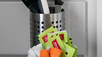 Suporte de utensílios de cozinha com espátula, faca e escumadeira.