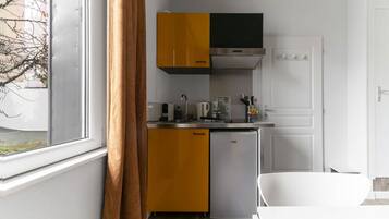 Coffee/tea maker, toaster, cookware/dishes/utensils, dining tables