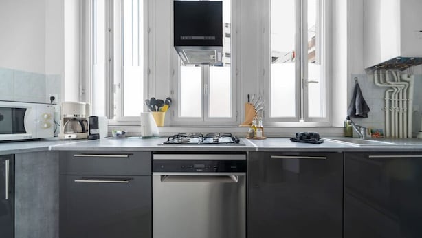 Une cuisine moderne équipée d’un lave-vaisselle, d’une cuisinière et d’un four à micro-ondes.
