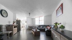 Un salon moderne comprenant un canapé, une table basse et un coin repas avec des chaises et une table.