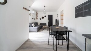 Ein modernes Interieur mit Essbereich, einer Couch und einem an der Wand befestigten Kalender.