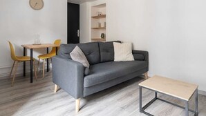 A modern living room with a grey sofa, wooden coffee table, and yellow chairs. - Air-cond duplex apartment in the city center (Vichy)