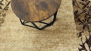 Deux tables en bois, dotées de pieds en métal, l’une étant plus grande que l’autre, et une plante en pot posée sur la plus petite des deux.