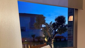 A modern room with a wooden chair and a large window. - Modern Villa in Sicily, comfort, relax, garden and parking (Marsala)