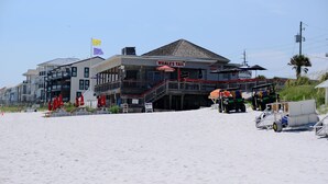 Ein Restaurant direkt am Strand namens 'Whale's Tail' mit Terrassenbestuhlung und einer sichtbaren Deckfläche.