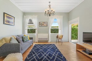 A living room with a sofa, TV, and a patterned rug.