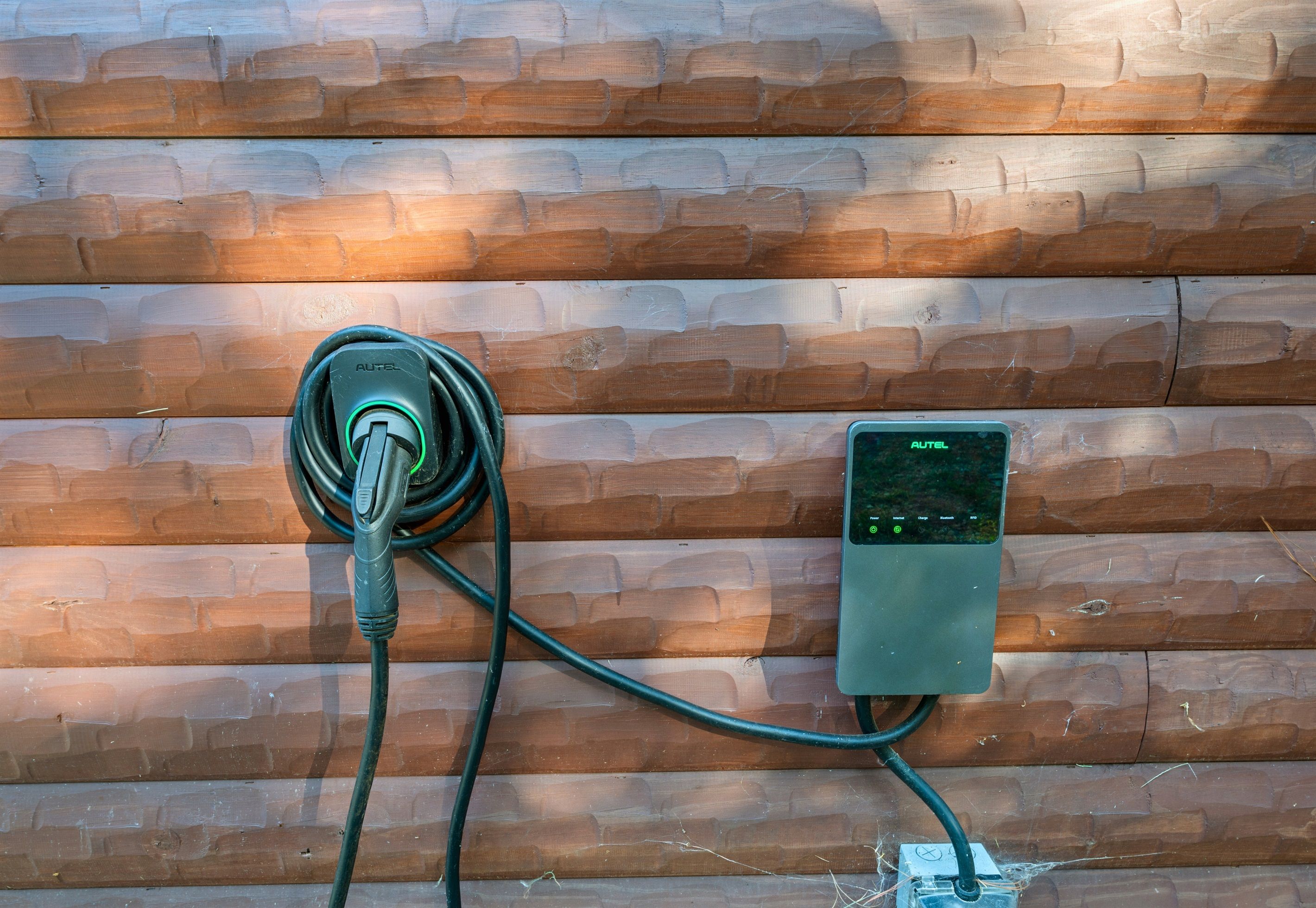 Una estación de carga para vehículos eléctricos instalada en una pared de ladrillo.