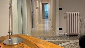 A modern hallway with a wooden desk, a floor lamp, and a radiator. - B&B Genova Holiday (Genoa)