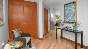 A modern living room with a wooden floor, a grey sofa, a coffee table, and a painting on the wall. - Liftside C22 | Ski-In/Ski-Out 3BR at Cascade Village (Vail)