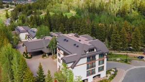 A residential area with multiple houses, each with a sloped roof and surrounded by dense forest. - Liftside C22 | Ski-In/Ski-Out 3BR at Cascade Village (Vail)