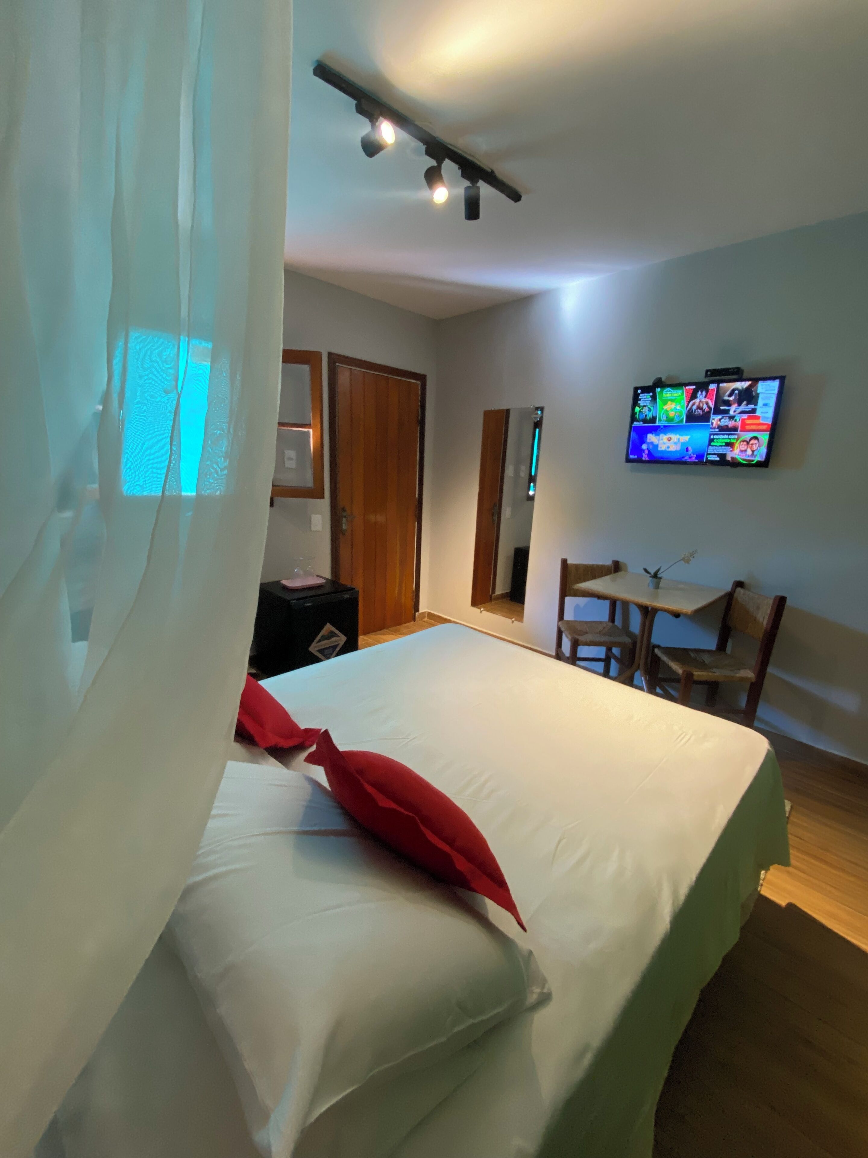 Una habitación de hotel con cama, escritorio, televisión y armario.