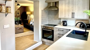 A modern kitchen with a built-in oven, a stovetop, and a sink. There are wooden cabinets and a countertop. - Central Ellesmere -sleeps2 - Parking - Petfriendly (Ellesmere)
