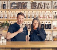 A bar with shelves of bottles and a sign that reads "GIN BAR".