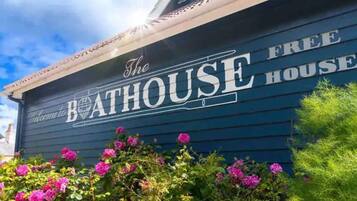 Un bâtiment sur lequel on peut lire l’inscription suivante : « THE BATHHOUSE FREE HOUSE ».