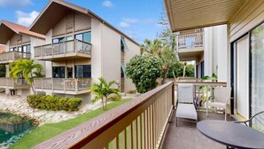 A hotel with multiple balconies, a pool, and a patio area with outdoor seating. - Lovely 2 Bedroom Lake View Home on Siesta Key! (Siesta Key)