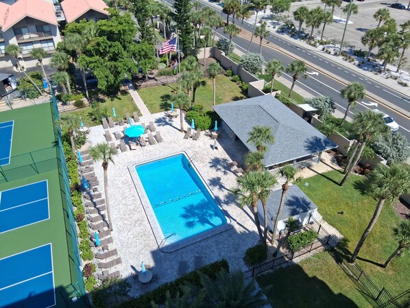 An aerial view of a property with a swimming pool, tennis courts, and a parking area. - Lovely 2 Bedroom Lake View Home on Siesta Key! (Siesta Key)