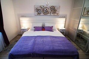 Cozy retreat with a large bed, bedside tables, and a wall-mounted artwork.
