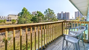 A wooden deck with a view of buildings in the distance.