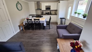 Un espacio habitable compacto con comedor, kitchenette y zona de estar.