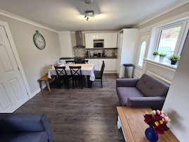 A compact living space with a dining area, kitchenette, and seating area.