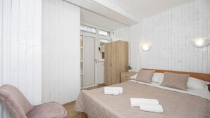 A bedroom with a bed, a chair, a wardrobe, and a nightstand. - Villa Vinovo 1 Bedroom Apartment (Kastela)