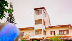 A swimming pool with a view of a two-story building in the background. - Pousada da Mércia (Salvador)