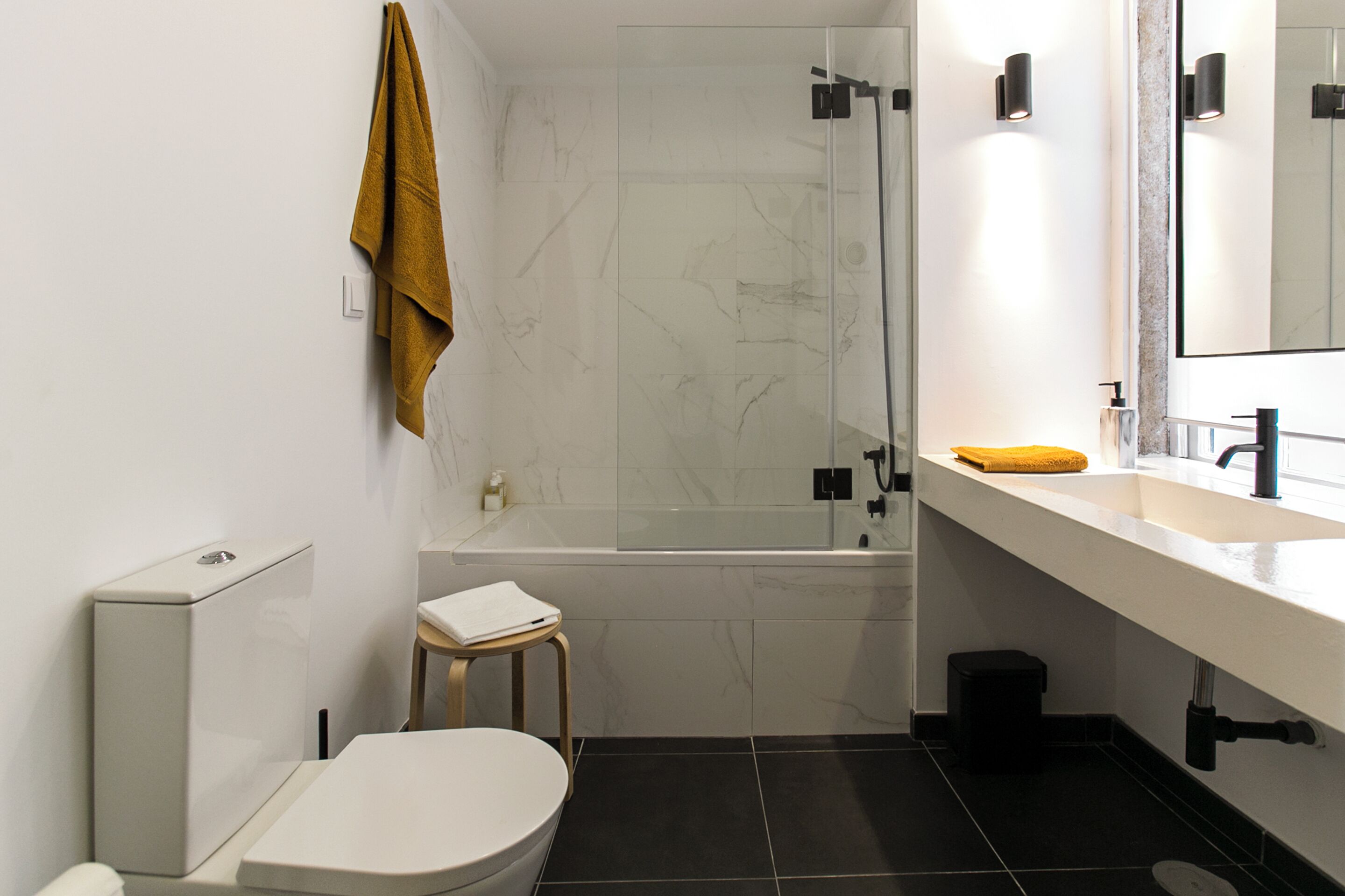 A modern bathroom with a toilet, sink, and bathtub.