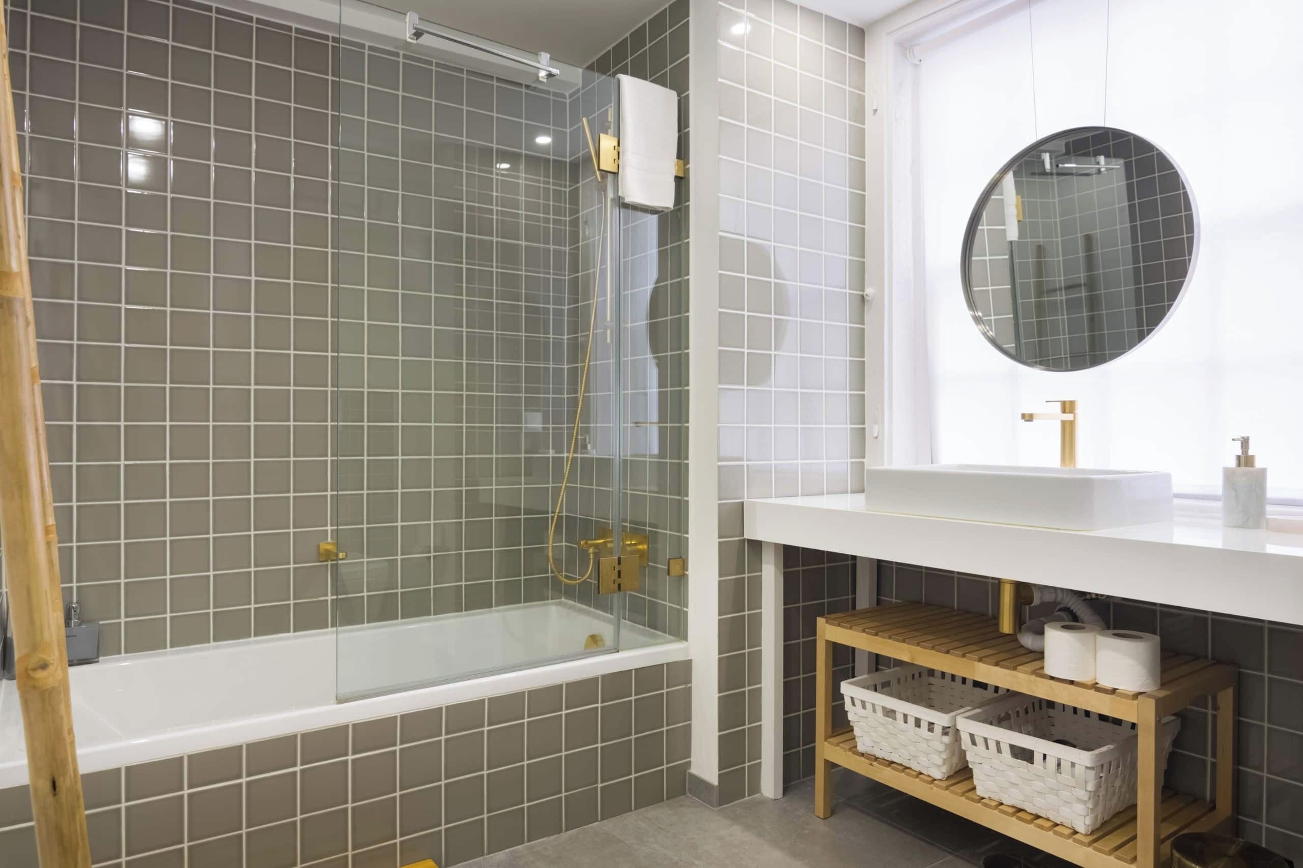 A modern bathroom with a glass-enclosed shower, a white sink, and a wooden shelf with baskets.