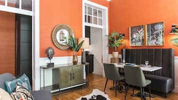 Un espace repas comprenant une table, des chaises, un banc et une plante décorative.