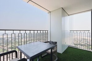 Un balcon avec une table et des chaises, une vue sur le paysage et une balustrade.