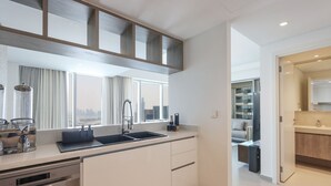 Una cocina moderna con un ventanal grande, electrodomésticos de acero inoxidable y vistas al horizonte de la ciudad.
