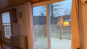 A room with a large sliding glass door leading to an outdoor deck.